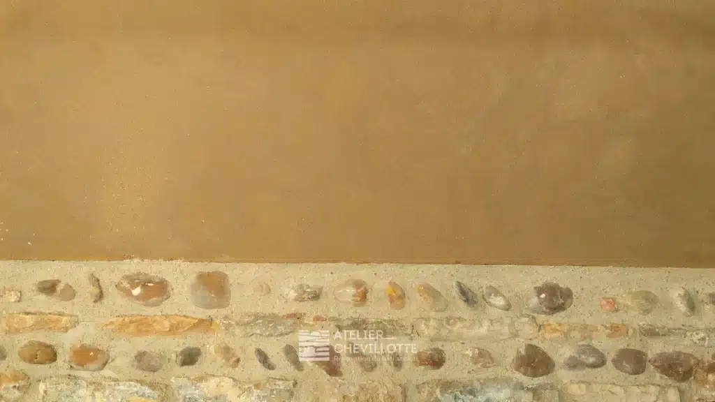 Soubassement en pierre avec mur en pisé enduit de terre, sain et sans humidité.