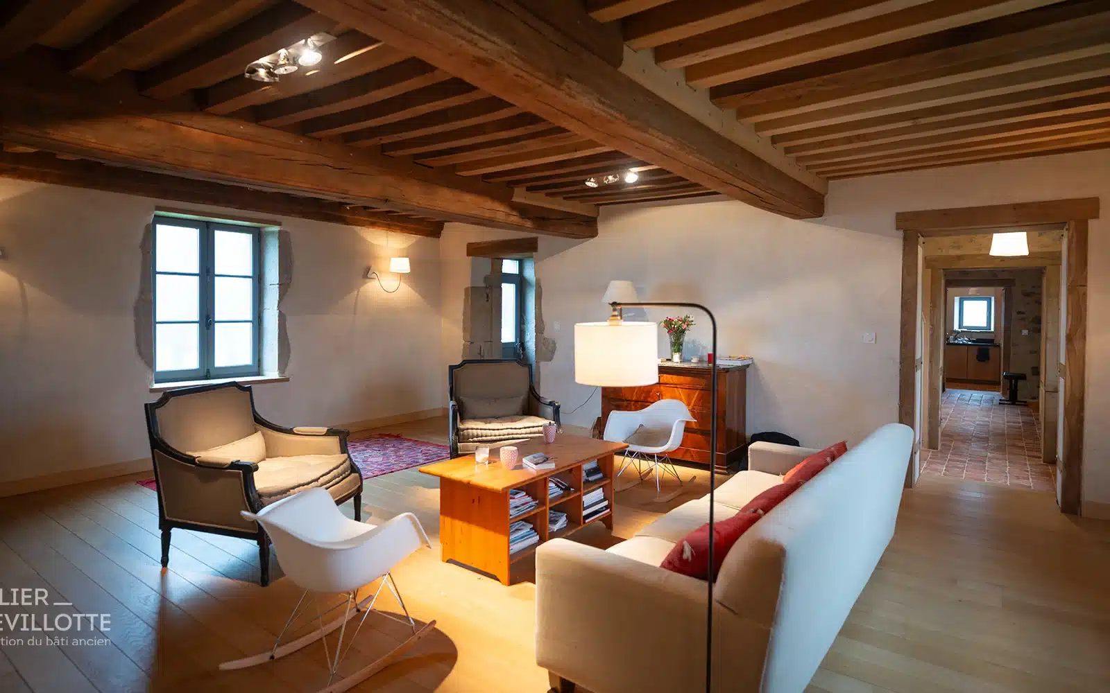 Intérieur lumineux d’une maison paysanne après réhabilitation : poutres et plancher à la française restauré, enduits chaux chanvres, parquet chêne pour une ambiance rurale élégante et chaleureuse.